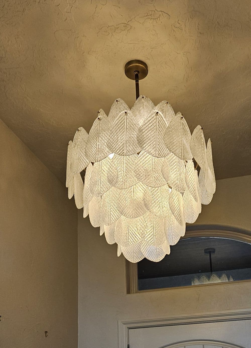 Elegant leaf-patterned chandelier illuminating a stylish interior space.