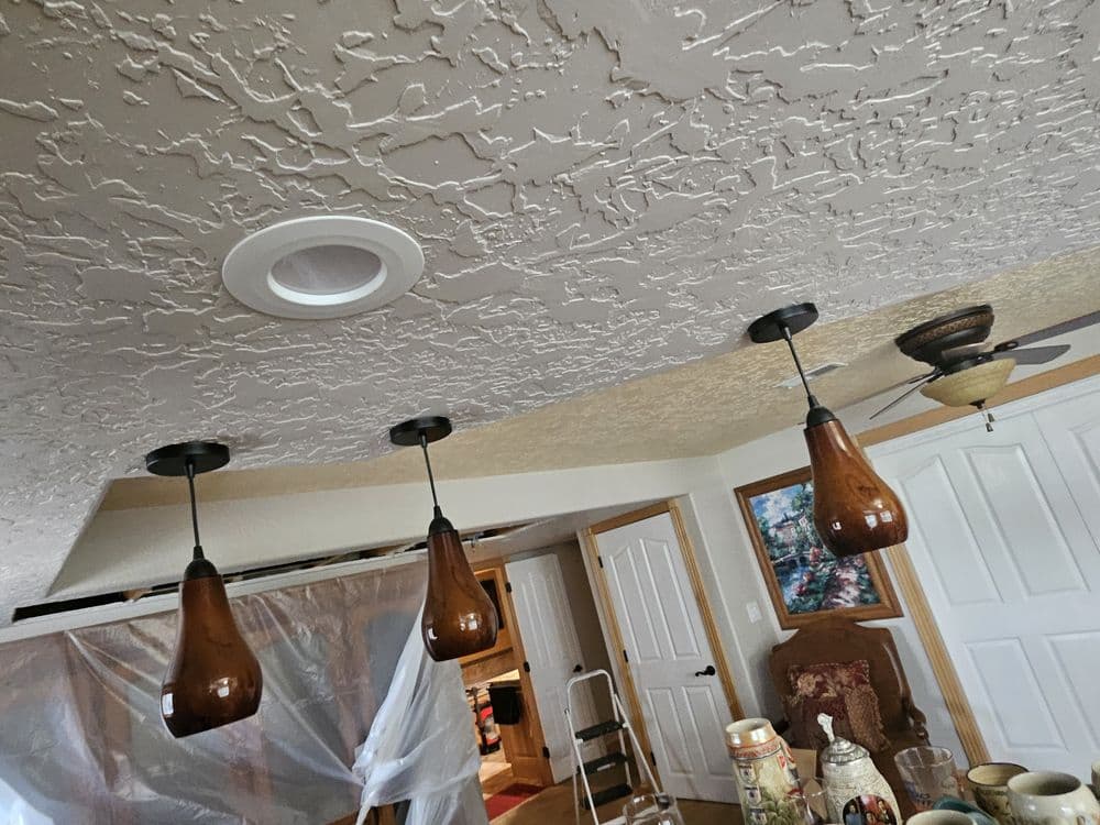 Modern ceiling with three pendant lights and textured design in a cozy interior setting.